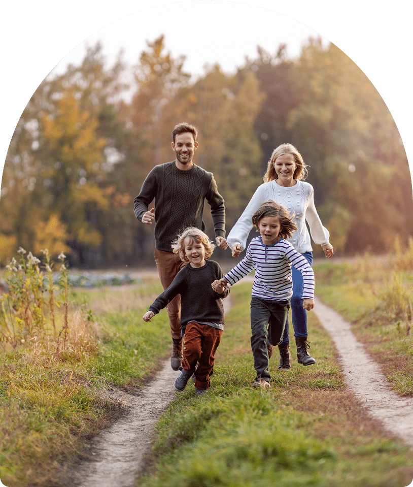 Family of four running on autumn country path