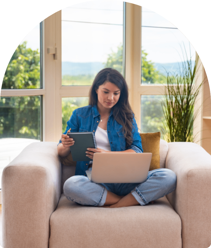 Woman using laptop and taking notes