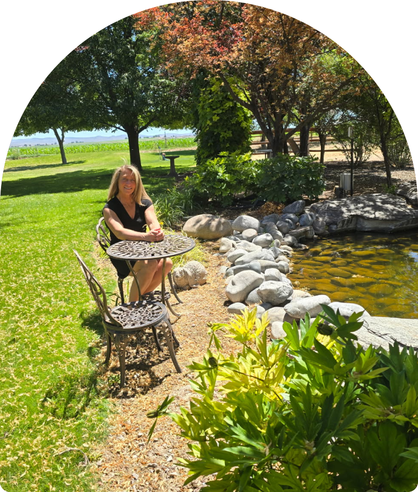 Person sitting at patio table by pond